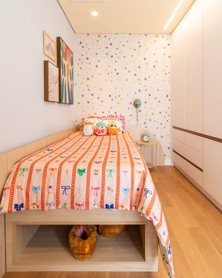 Quarto infantil com armário claro de parede inteira e cama com nicho