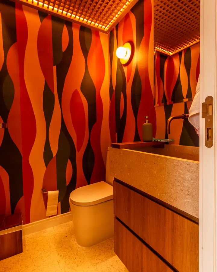 Lavabo com papel de parede em ondas laranja e gaveteiro de madeira