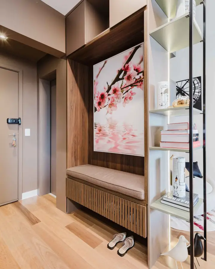 Hall com banco ripado, painel em madeira escura e quadro de flores