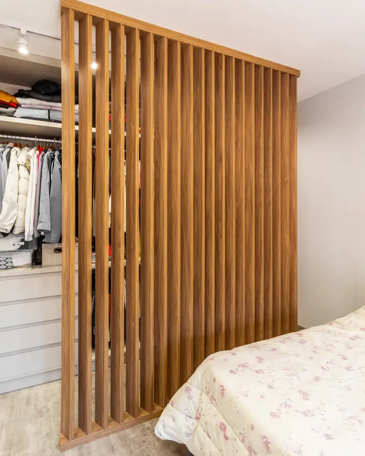 Divisória de ripas de madeira entre a cama e o closet